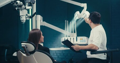 Patient at dental consultation with dentist discussing oral care and treatment in a clean, professional clinic. Concept — dental services, orthodontics, oral hygiene campaigns, healthcare education.