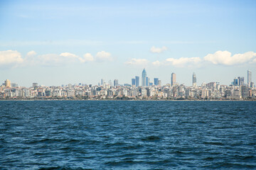 Fototapeta premium Spring, Istanbul view from the sea. Panorama of the city with a beautiful wave and clouds in the background . high-rise buildings, Turkey