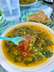 Spoonful of Spicy Turmeric Rice Porridge with Greens and Tofu