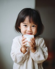 Cheerful Child Holding White Cup with Both Hands in Cozy Atmosphere