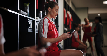 Cellphone, woman and athlete in locker room for game, match or practice with scrolling on social media. Tech, relax and female soccer player with phone for networking on mobile app in changing area.