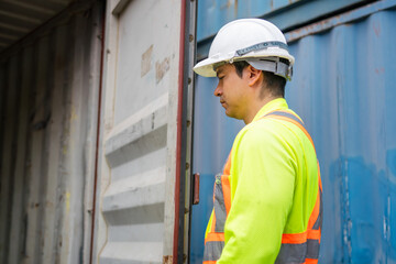 Engineer man checking containers box in in industry containers yard, Foreman dock worker inspecting containers box