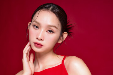 赤い背景で撮影をした若い女性のアジアンビューティーイメージ