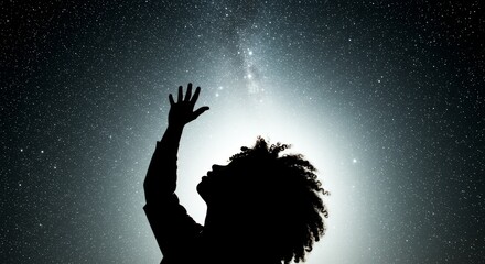 Silhouette of a person reaching towards the stars in the night sky