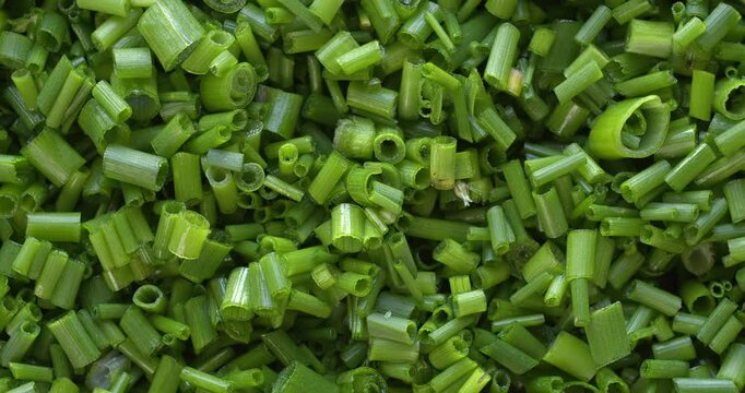 Close-up view of chopped chives background texture. Chives are a tasty addition to dishes, and a source of numerous health benefits. Table spin. 