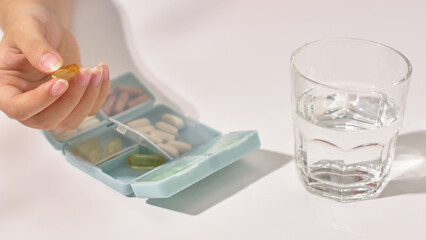 A blue personal pill box, compact and flexible for travel. Inside the box are different types of...