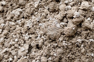 Close up uneven brown construction sand pile texture isolated on horizontal full frame background.