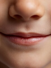 Obraz premium Macro of lips of a 5 year old tanned boy, smiling slightly, natural light, white background, conveying innocence, freshness.