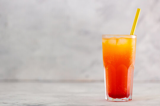Dirty Soda with Yellow Straw in Tall Glass on Gray Background, Copy Space