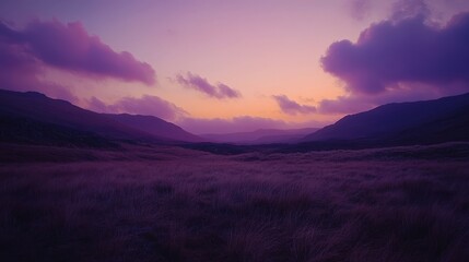 Obraz premium Breathtaking purple sunset over mountains, soft clouds harmonizing twilight hues in a tranquil valley landscape