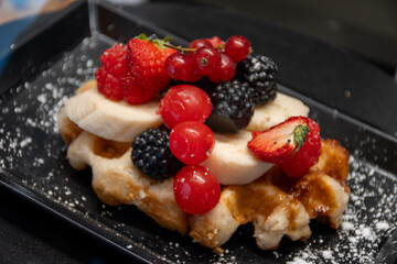 Baked belgian sugar waffles with various toppings, delicious sweet street food in Bruges, Flanders, Belgium