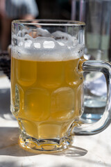 Belgian beer in glass in old brewery in Bruges, light or dark, tasty beverage, lunch with beer, tourist destination, Flanders, Belgium
