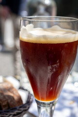 Belgian beer in glass in old brewery in Bruges, dubbel dark, tasty beverage, lunch with beer, tourist destination, Flanders, Belgium