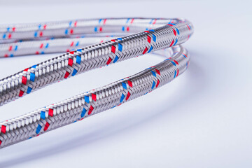 A water tap and a hose in a metal braid. Accessories for the repair of water supply.
