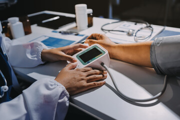 Nurse measuring blood pressure of elderly woman at table, closeup. Assisting senior generation