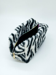 Fur open cosmetic bag with zebra print on white background
