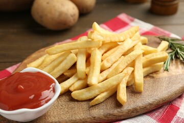 Tasty french fries with ketchup and rosemary on wooden table, closeup