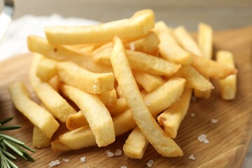Fresh tasty french fries on wooden table, closeup