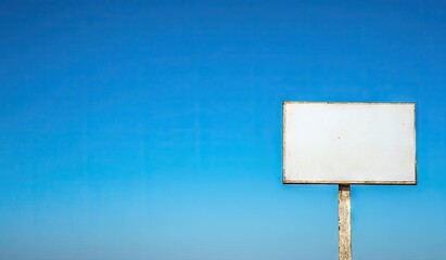 Empty billboard against a vibrant blue sky