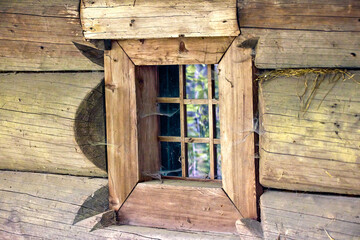 a small square window in an old wooden house of a wealthy Ukrainian peasant