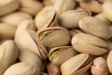 bunch of cracked pistachios with green nuts inside, the salted pistachios on the table are more delicious, piled together, top view