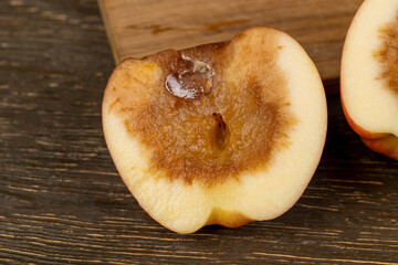 cut ripe apple covered with rot due to long storage
