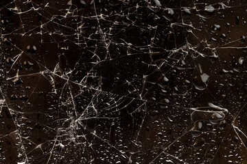 water droplets covered broken glass with a lot of damage on a black background, wet glass broken into many pieces
