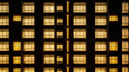 Modern Office Building Facade with Yellow Lit Windows at Night