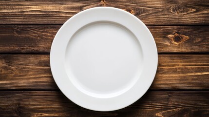 Empty white plate on a dark wooden table surface.
