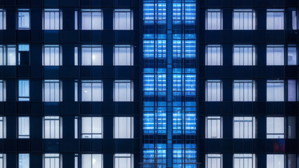 Fototapeta premium Symmetrical Urban Architecture with Blue Window Lights on Contemporary Building