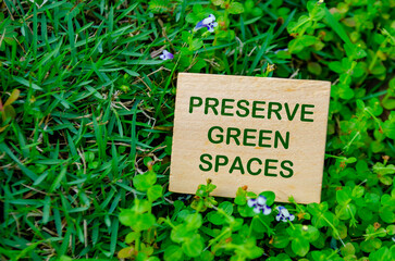 Top view of close up Preserve Green Spaces text on wooden block. For a greener tomorrow concept.