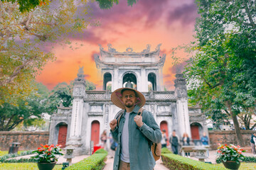 Young caucasian male tourist in traditional hat at Temper of Literature in Hanoi city, Vietnam