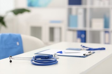 Stethoscope and paperwork on desk in doctor's office. Space for text