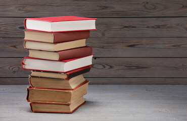 Stack of old books on grey wooden table, space for text