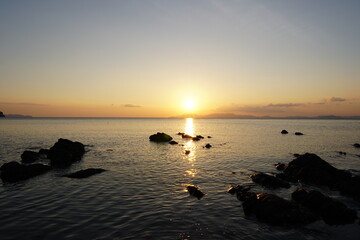 Serene Sunset Over Tranquil Ocean with Sunlight Dancing on Water’s Surface