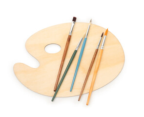 Wooden palette and brushes isolated on white, top view