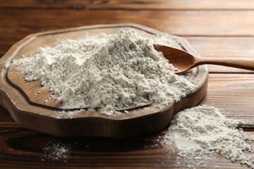 Pile of flour on wooden table, closeup