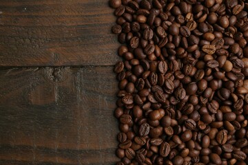 Fototapeta premium Aromatic coffee beans on wooden table, top view. Space for text