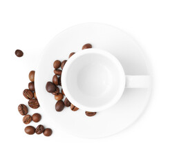 Aromatic coffee beans, cup and saucer isolated on white, top view