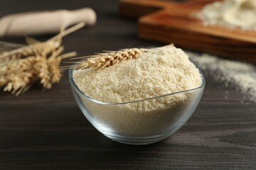 Flour and spike in bowl on dark wooden table, closeup