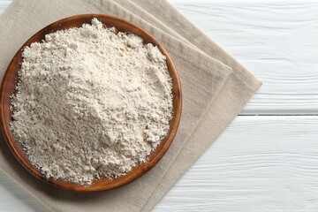 Flour on white wooden table, top view. Space for text