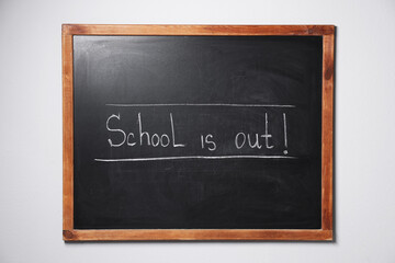 Phrase School's Out with exclamation mark on blackboard