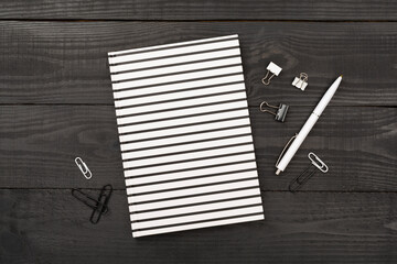 Notebook with stationary on wooden background, top view