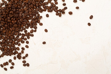 Roasted coffee beans with leaves on concrete background,top view