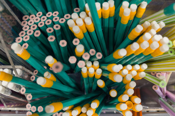 Heap of graphite pencils with and without erasers close-up