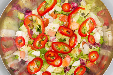 Salad of soft cheese, fresh vegetables and lettuce in bowl