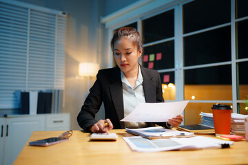 Exhausted businesswoman works late into the night, overwhelmed by stress, deadlines, and endless...