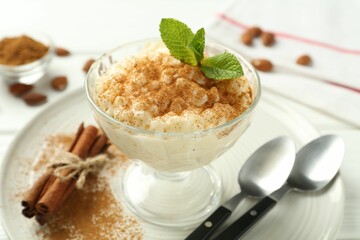 Delicious rice pudding with cinnamon and mint on table, closeup