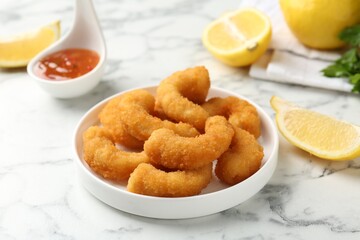 Tasty tempura shrimps and lemon on white marble table, closeup