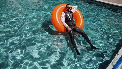 Businessman relaxing in pool on inflatable ring with vr headset under the sun